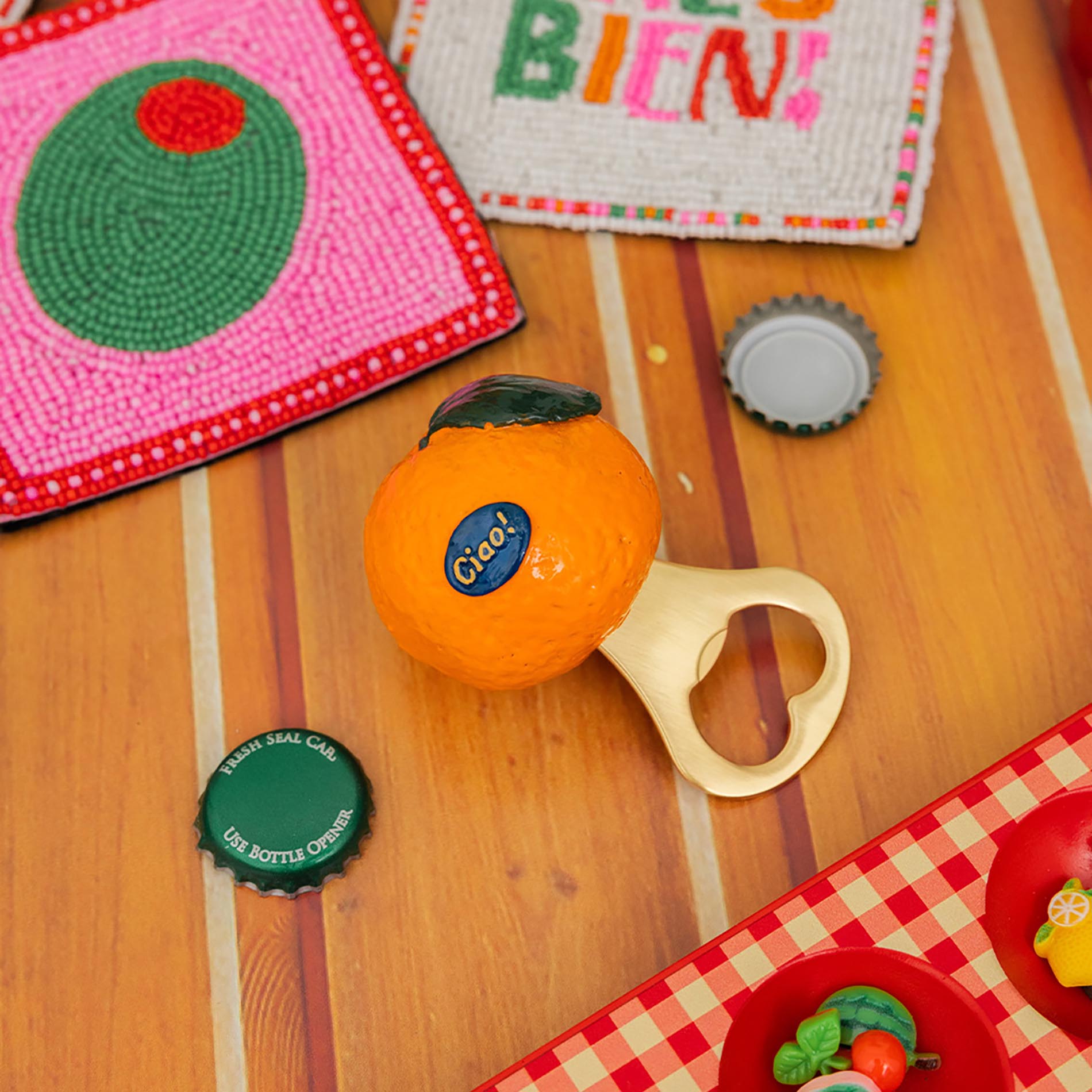 Orange ball with a bottle cap and toy on a wooden surface