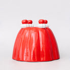 Red jelly mold vase with white and red decorations on a light gray background