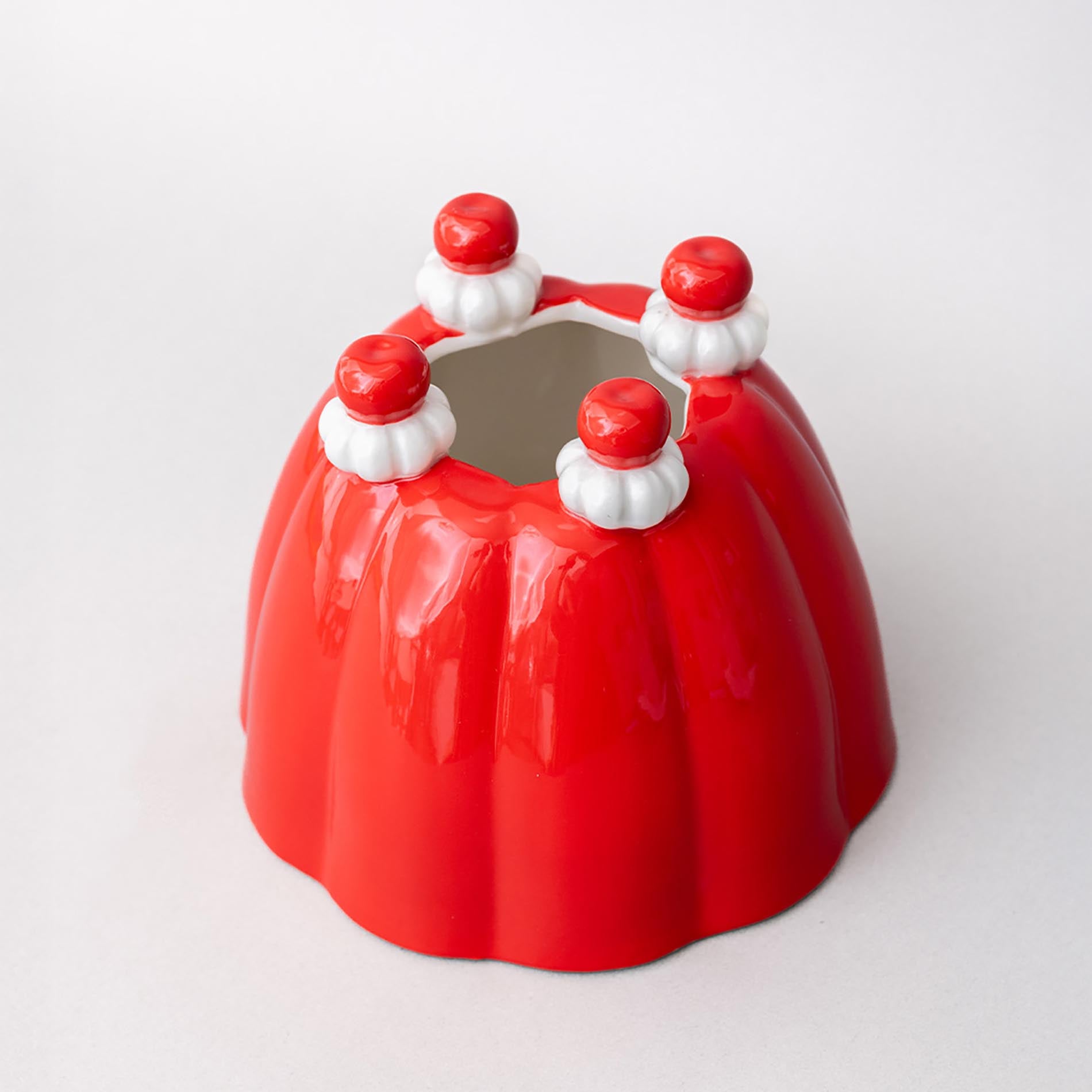 Red jelly mold vase with white and red decorative elements on a white background