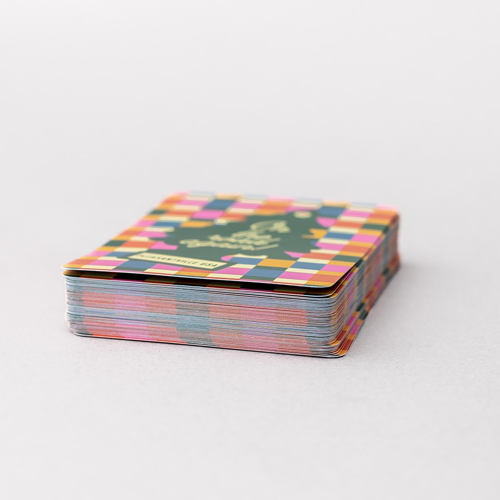 Stack of colorful playing cards with a geometric pattern on a white background