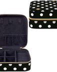 Black jewelry case with white polka dots and gold zipper, open to reveal compartments.