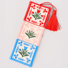 Decorative bookmark with floral patterns and a red tassel on a light gray background