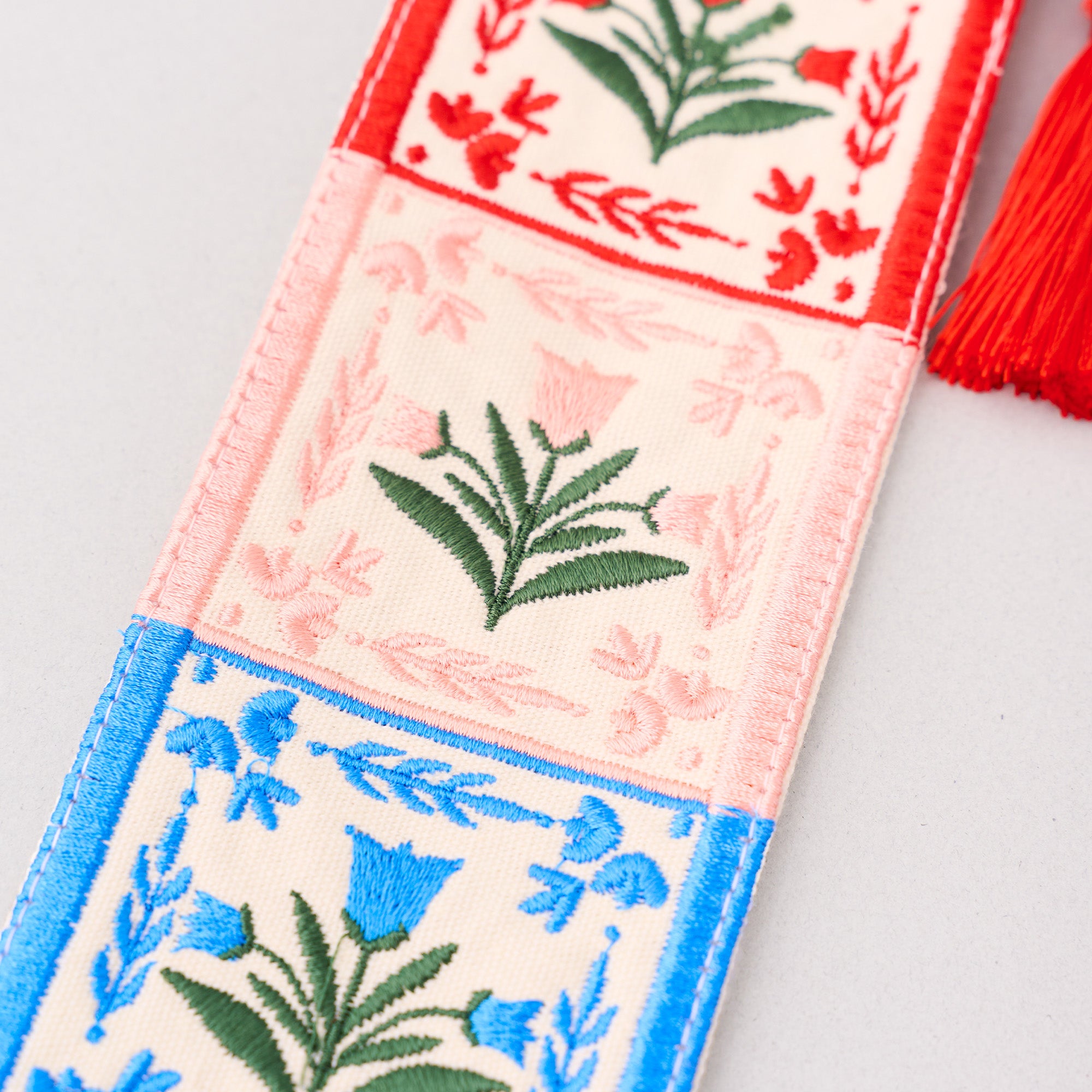 Decorative bookmark with floral patterns and tassels on a light gray background