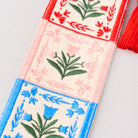 Decorative bookmark with floral patterns and tassels on a light gray background