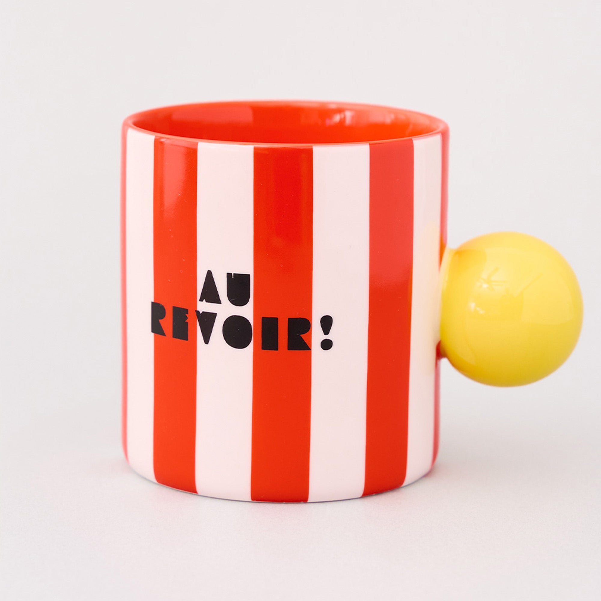 red and white vertical stripe mug with yellow ball handle and double sided typography with 'BONJOUR!' on one side and 'AU REVOIR' on the other