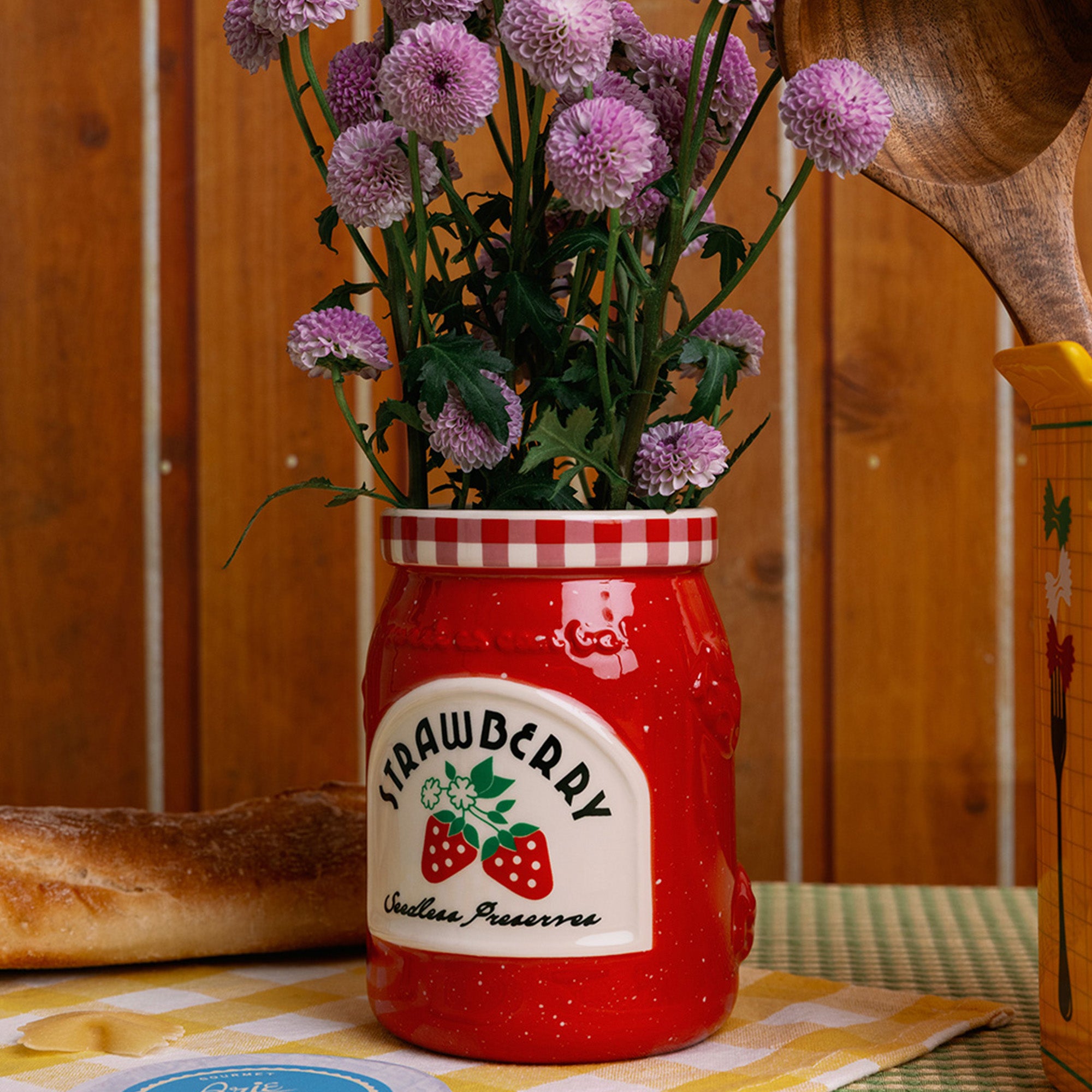side view of strawberry jam petite ceramic vase with a bouquet in the top