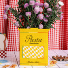 yellow pasta box vase with purple flowers inside