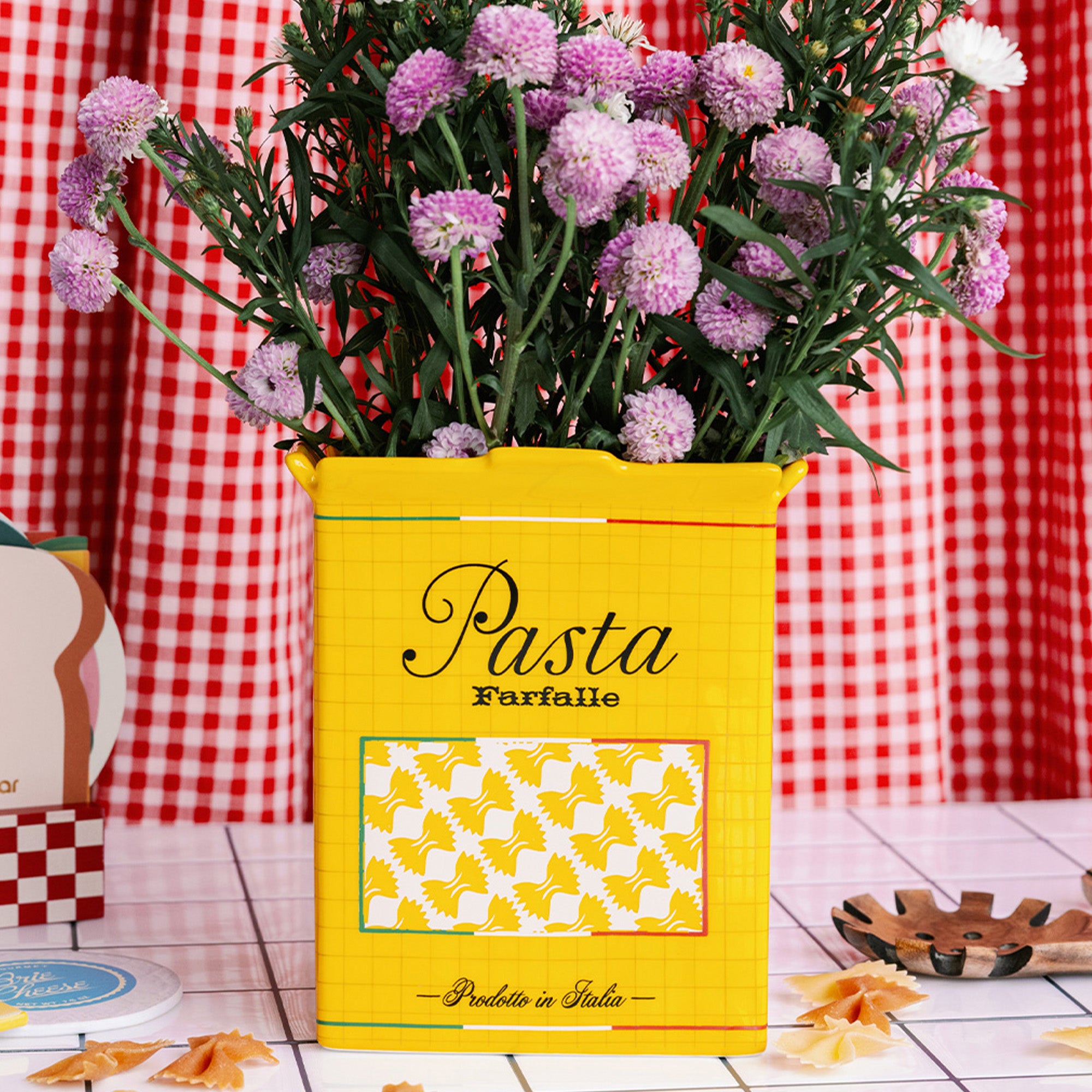 yellow pasta box vase with purple flowers inside