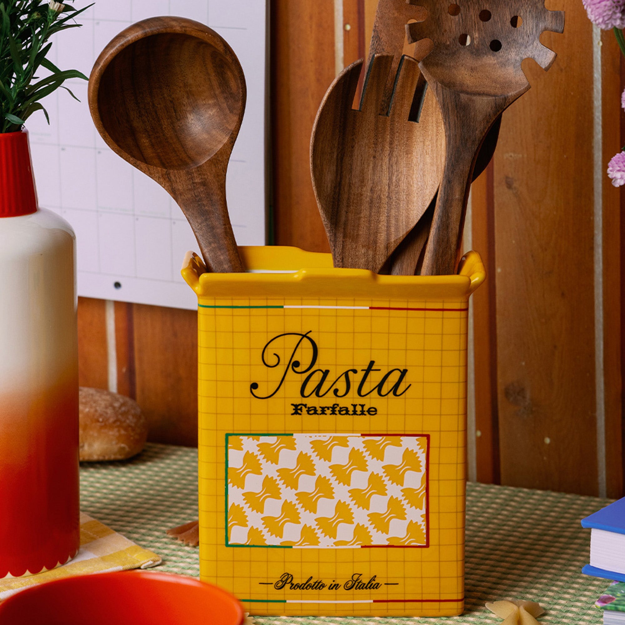yellow pasta box vase with wooden utensils inside