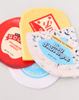 Four different types of cheese coasters with labels on a light gray background