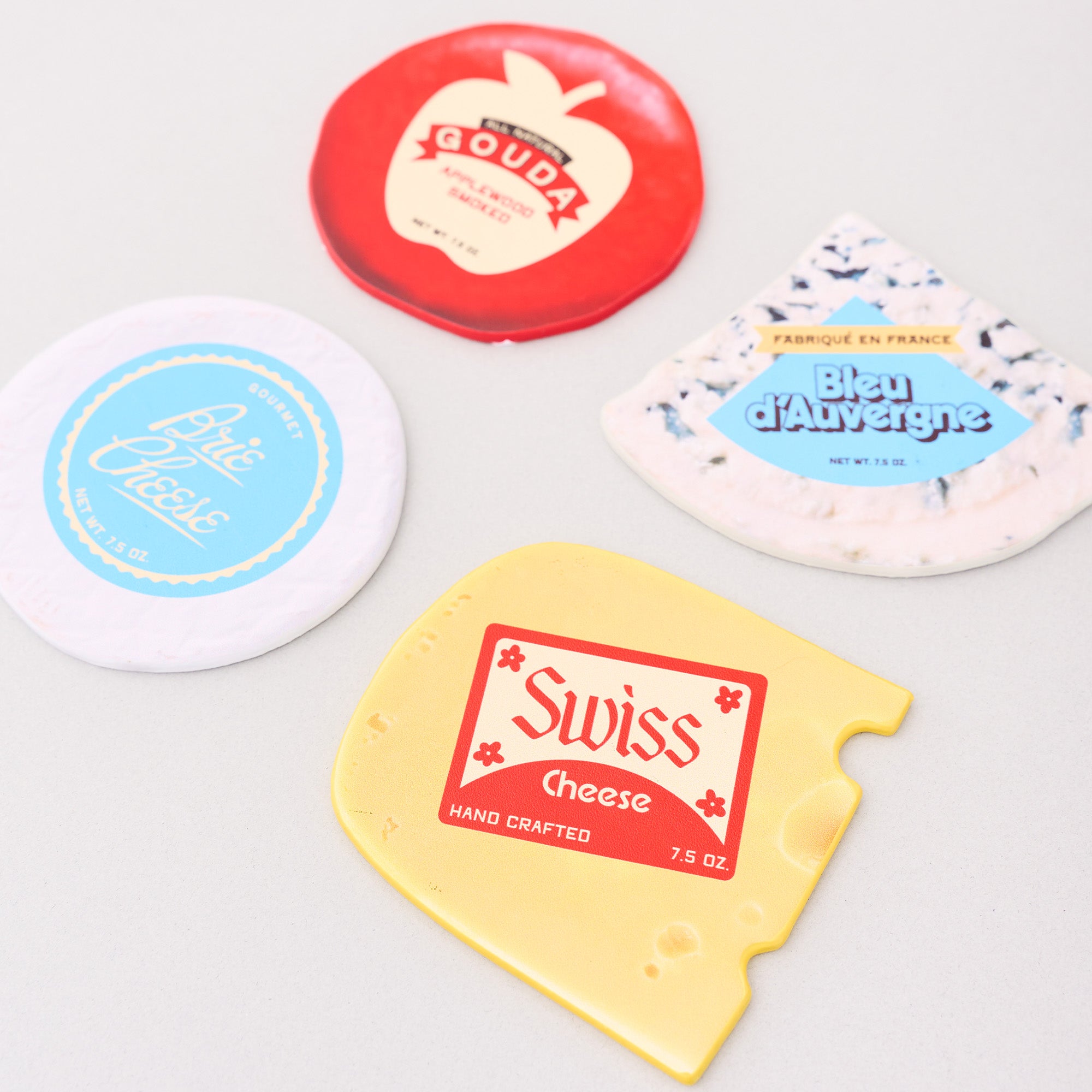 Collection of cheese-themed coasters on a light gray background