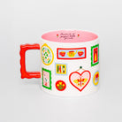 A white ceramic mug with a bright red handle and a colorful collection of illustrated tea-themed icons on the side, featuring a pink interior and the text 'Portraits of perfect little friends' printed inside.