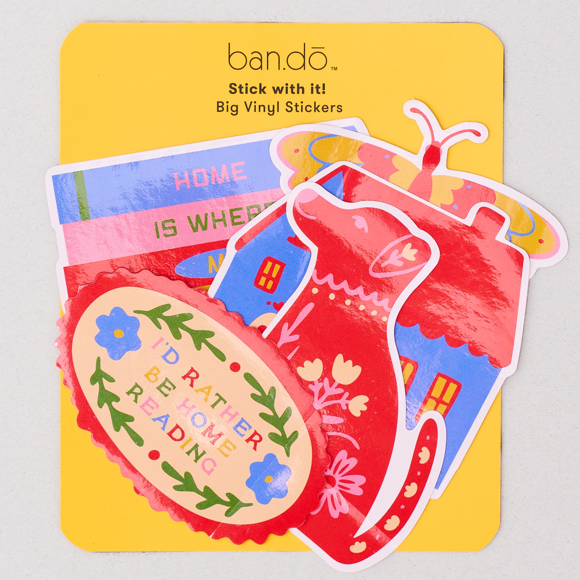 Set of colorful vinyl stickers on a yellow doormat with 'bando' branding.