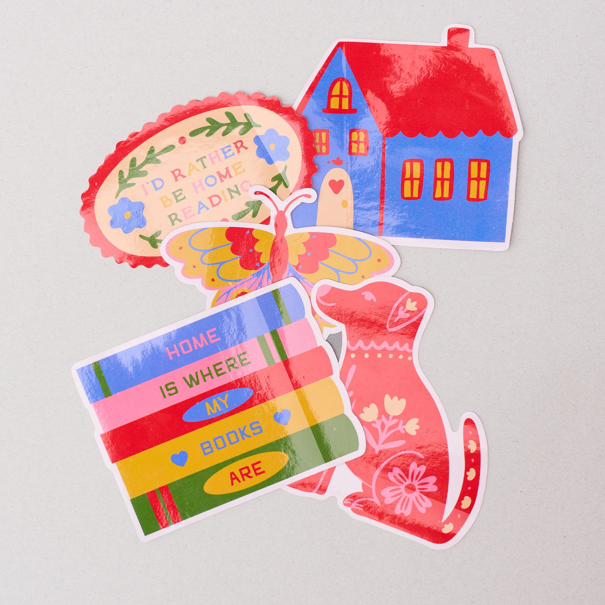 Set of colorful stickers with a house, bookshelf, and cat on a light gray background