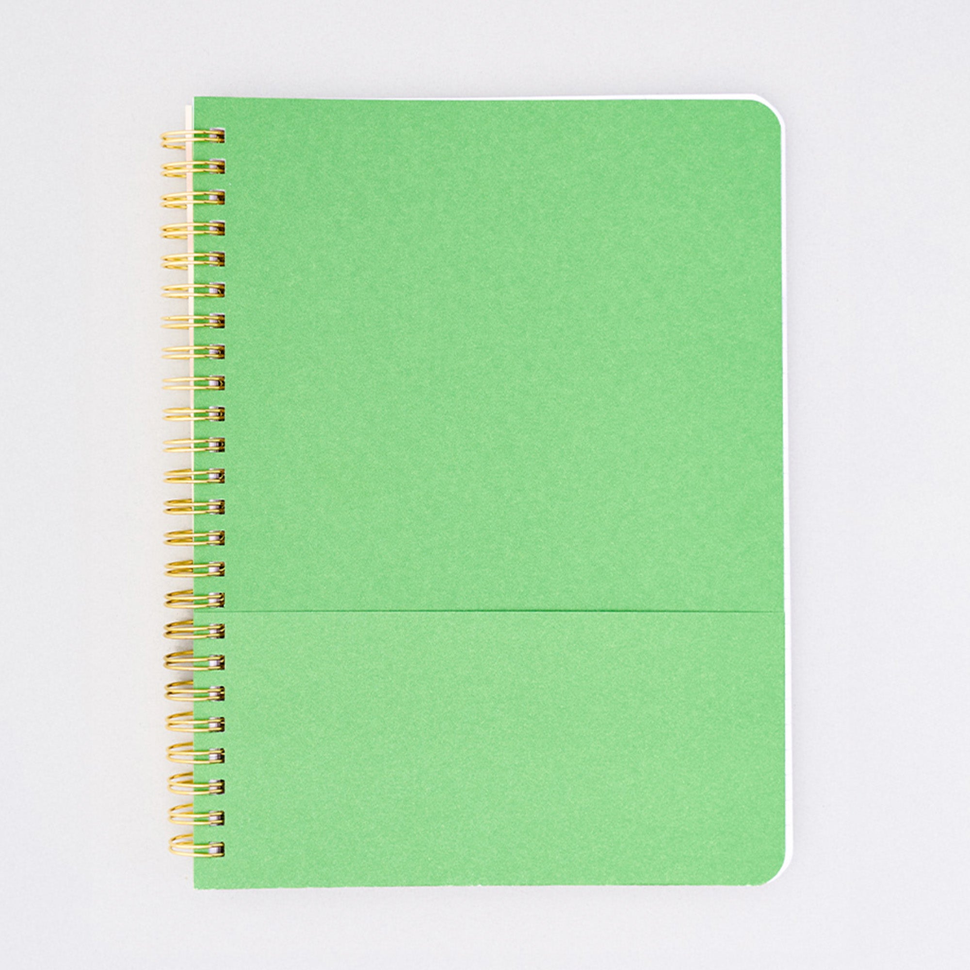 green interior pocket of cream mini notebook with colorful folk graphics and 'i'd rather be home reading' across the center