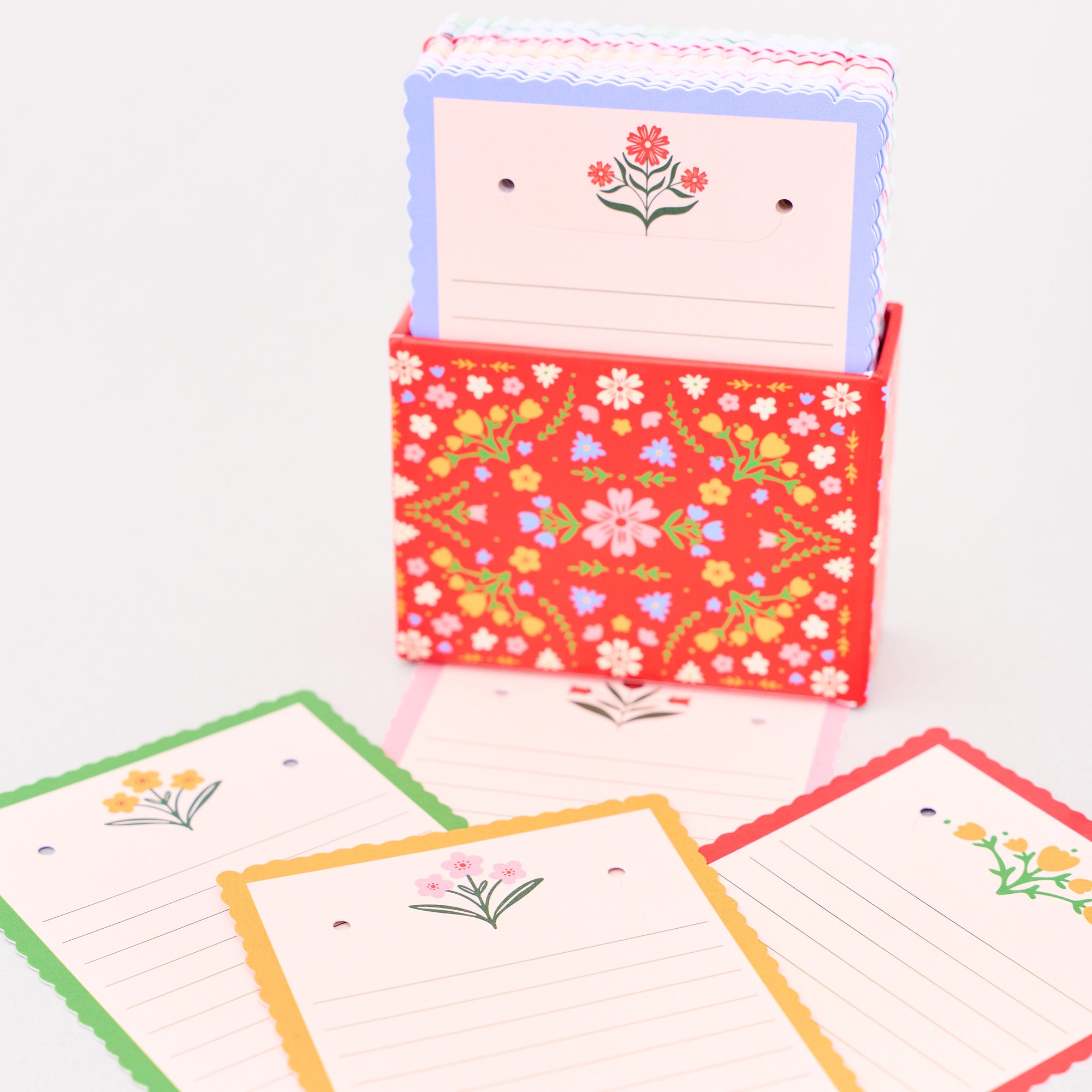 Floral notepad holder with colorful notepads on a white background