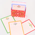 Set of colorful stationery items including cards and a box with floral patterns on a white background.
