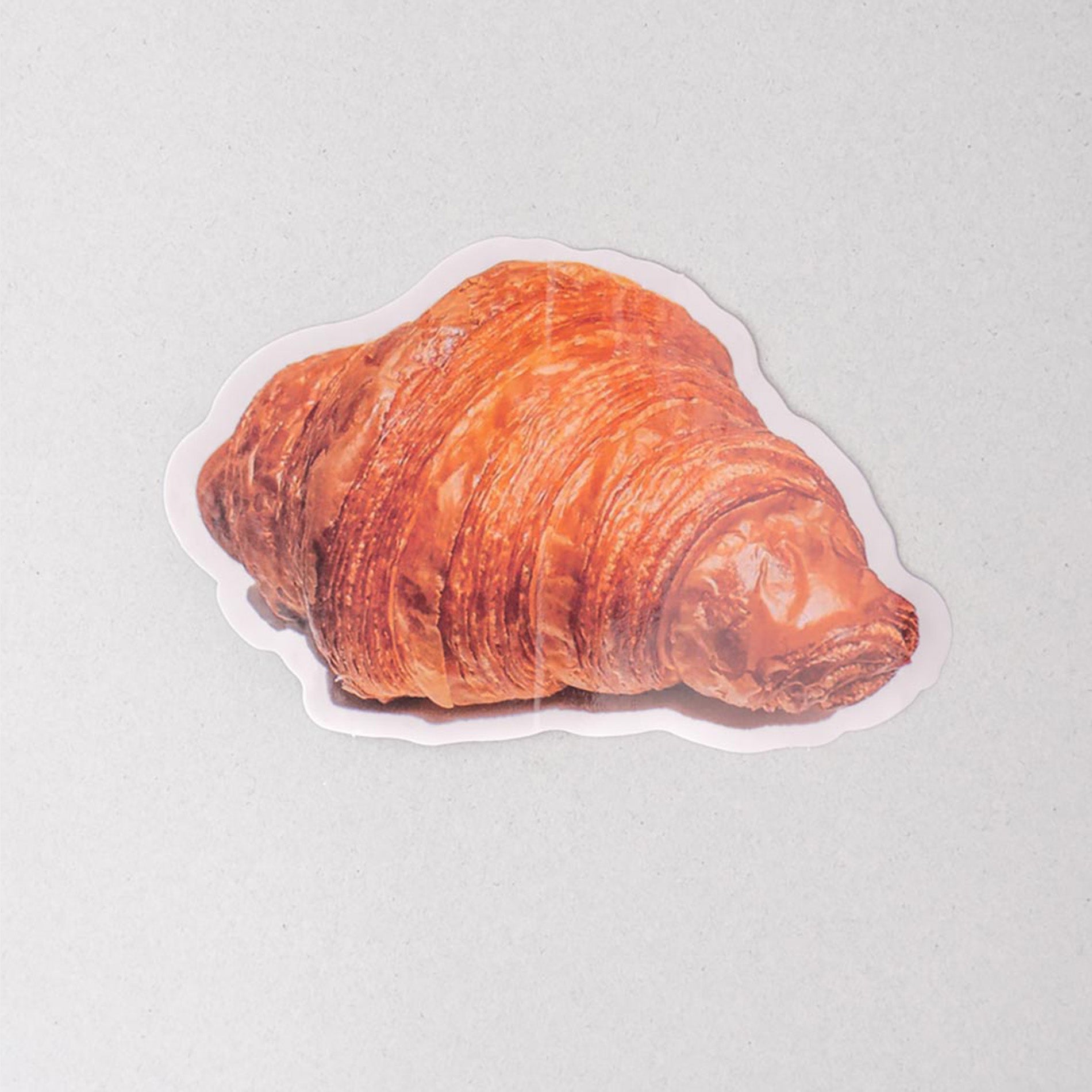 Sticker of a croissant on a light gray background