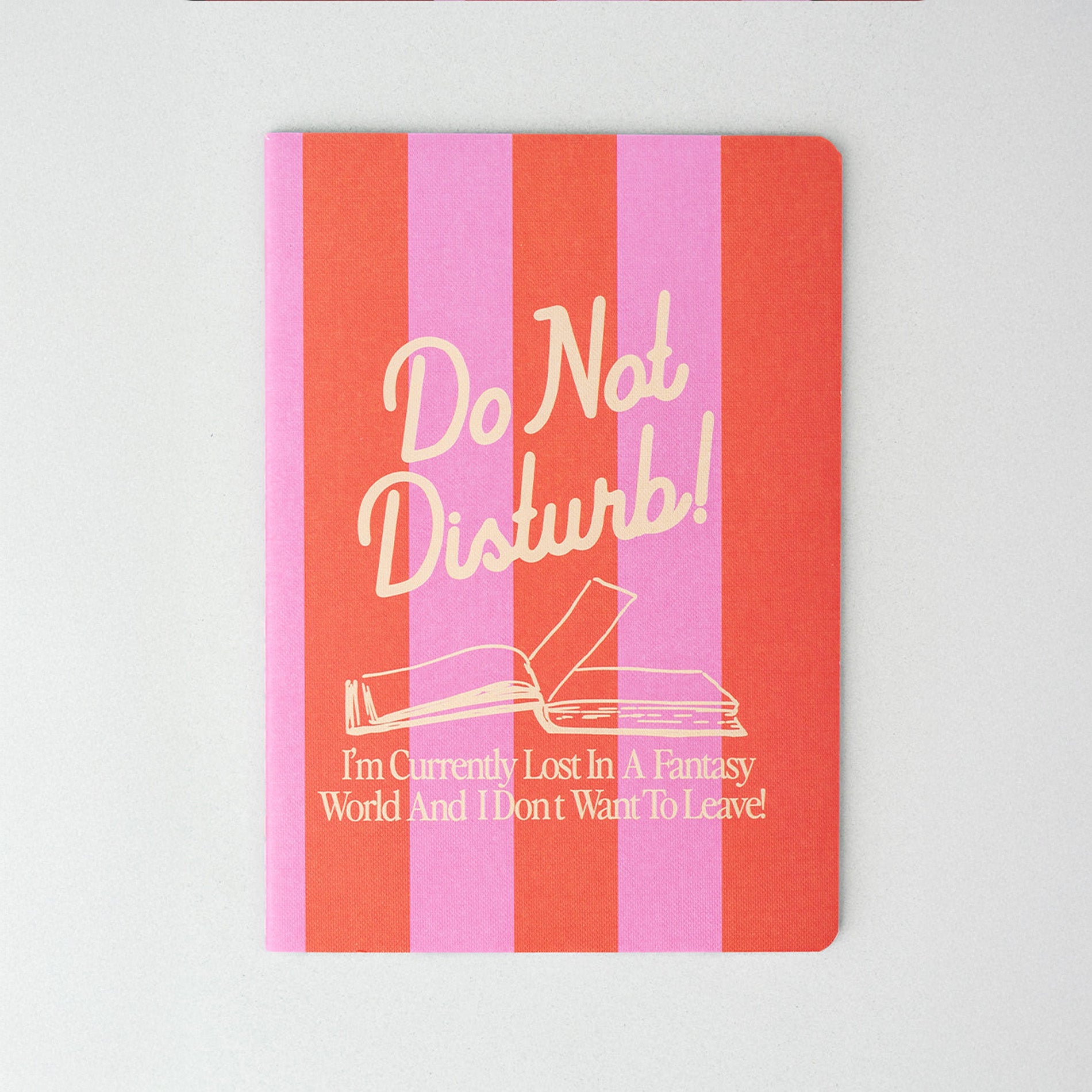 Notebook with pink and red striped cover and 'Do Not Disturb!' text on a white background