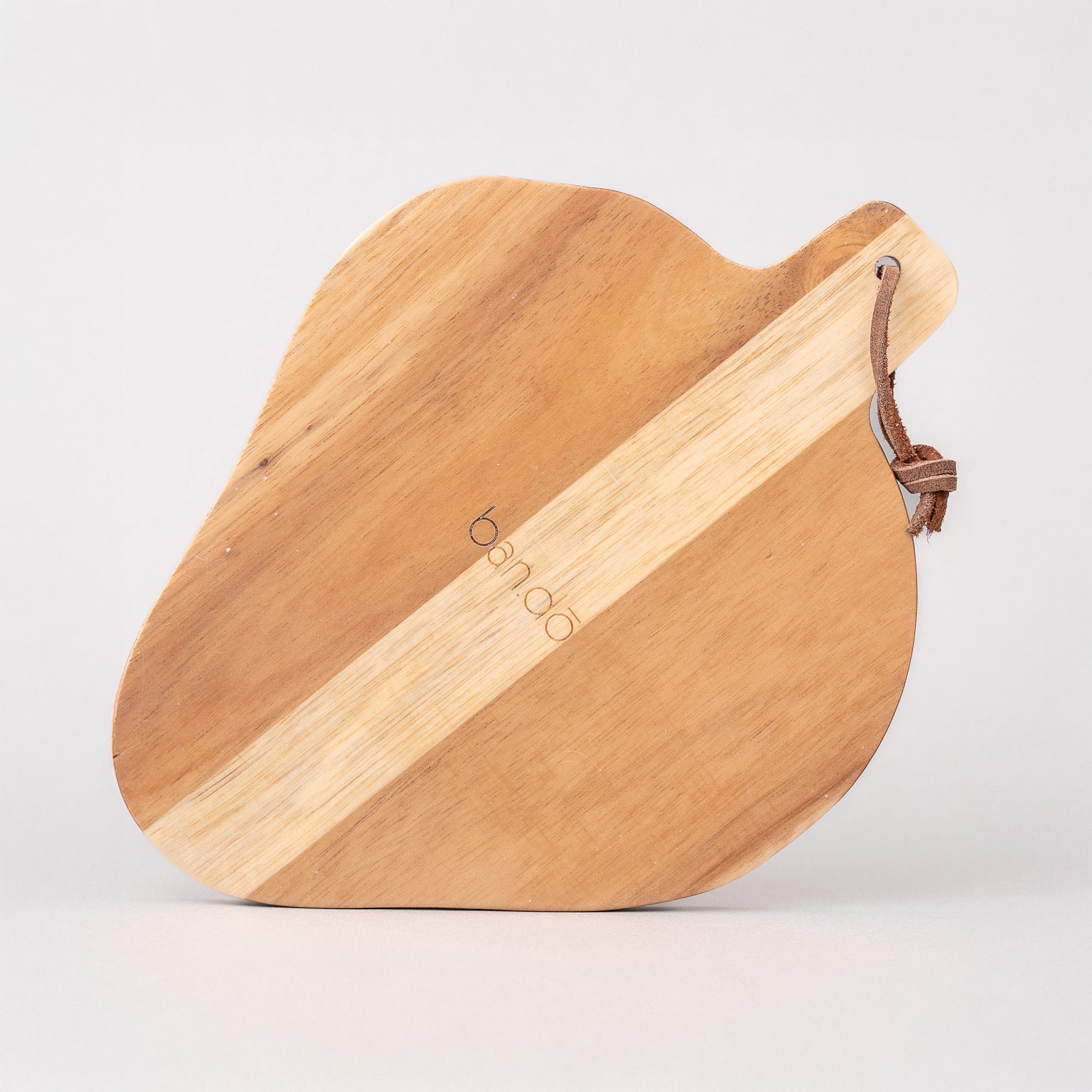 back view of Strawberry-shaped wooden trivet with a green leaf on a light gray background