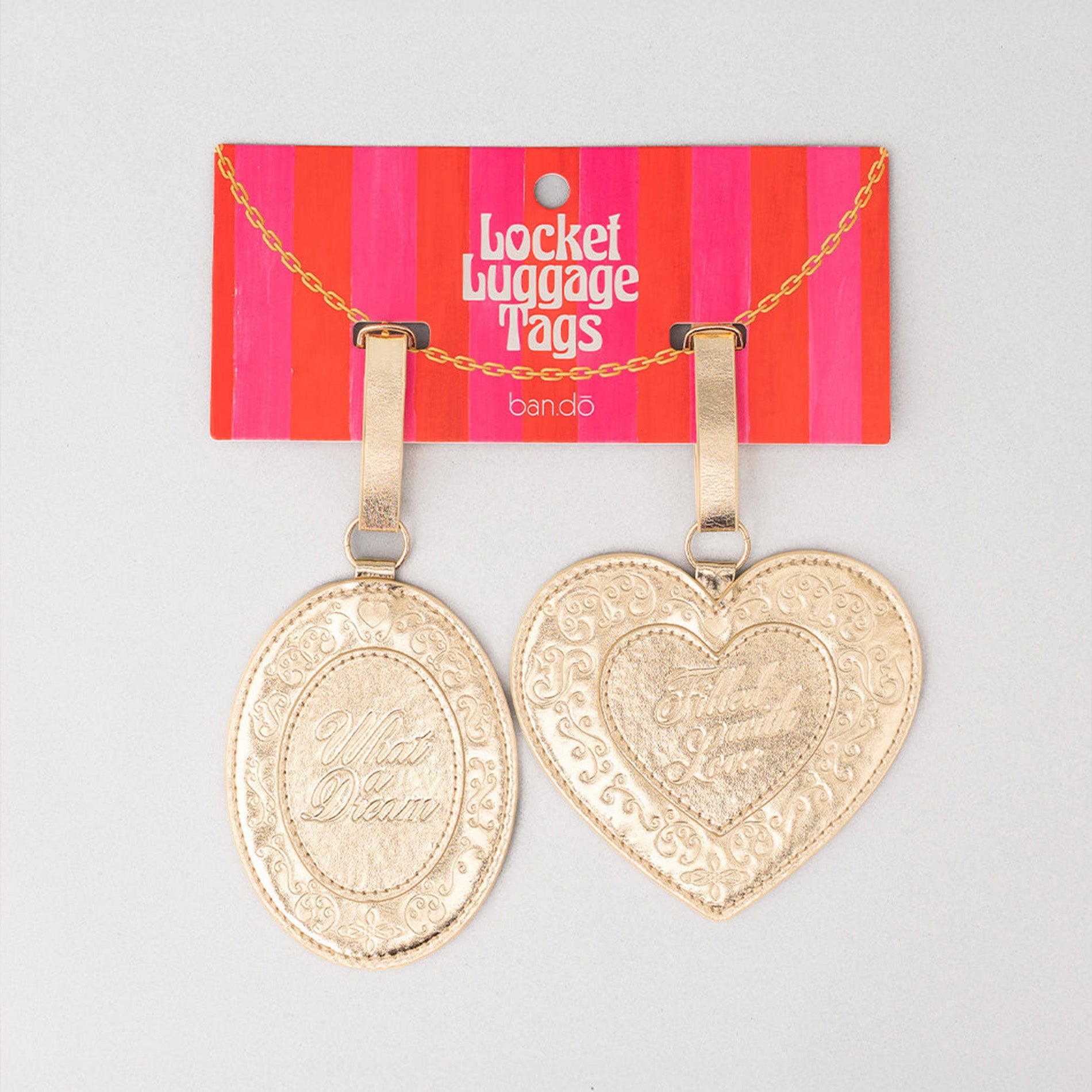 Two gold luggage tags, one oval and one heart-shaped, on a red and pink striped 'Badget Luggage Tags' card.