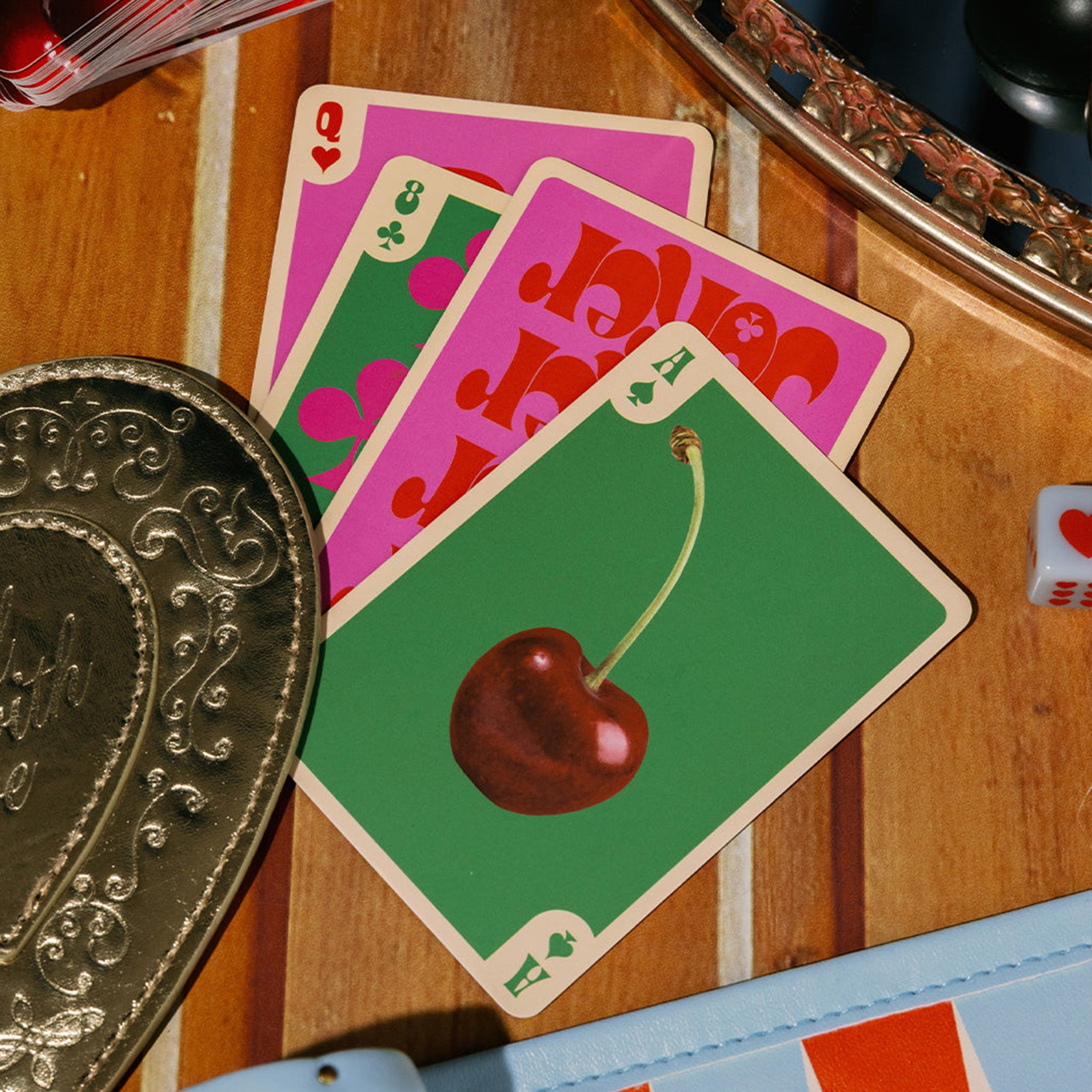 Playing cards with a cherry design on a wooden surface