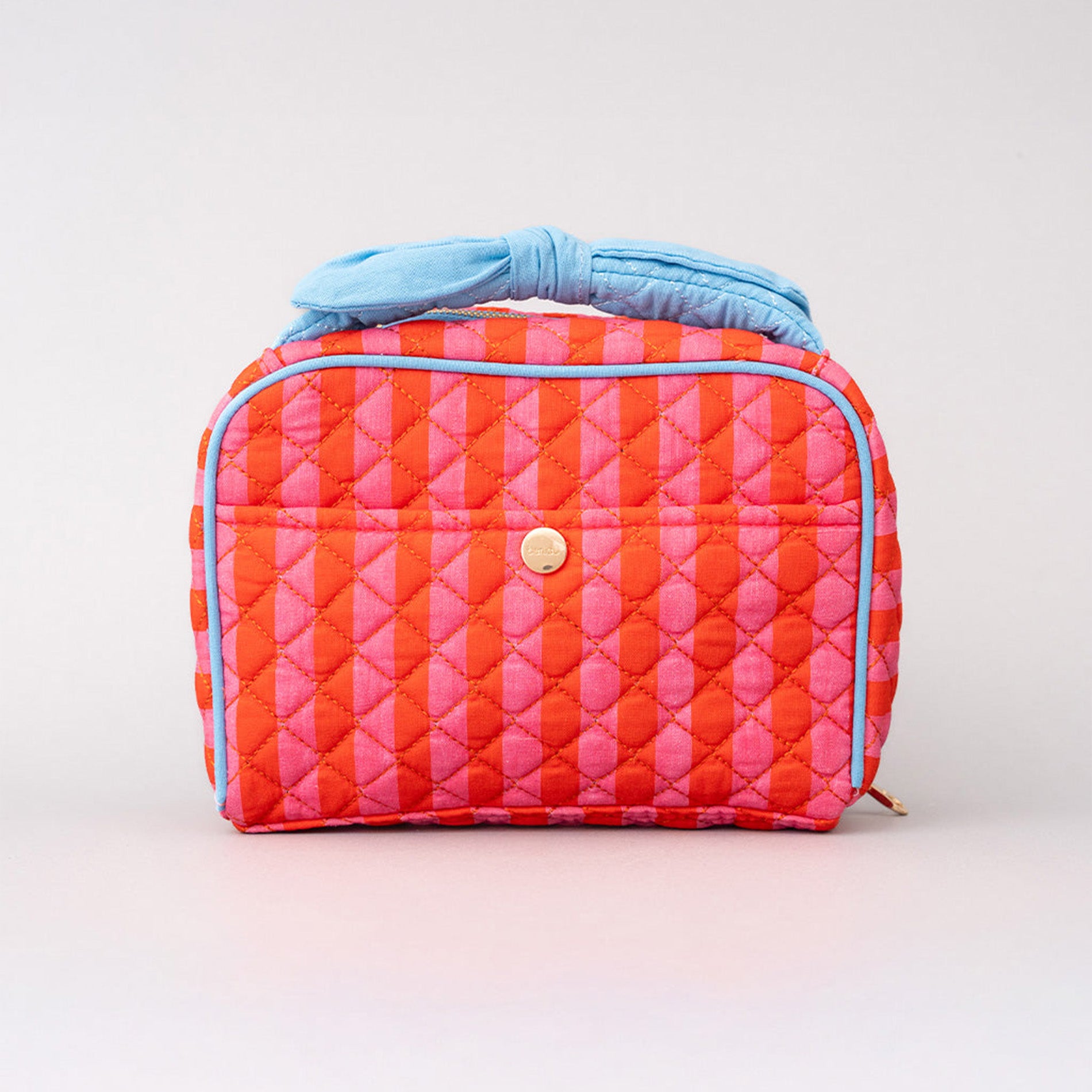 Quilted makeup bag with pink and orange stripes on a light gray background