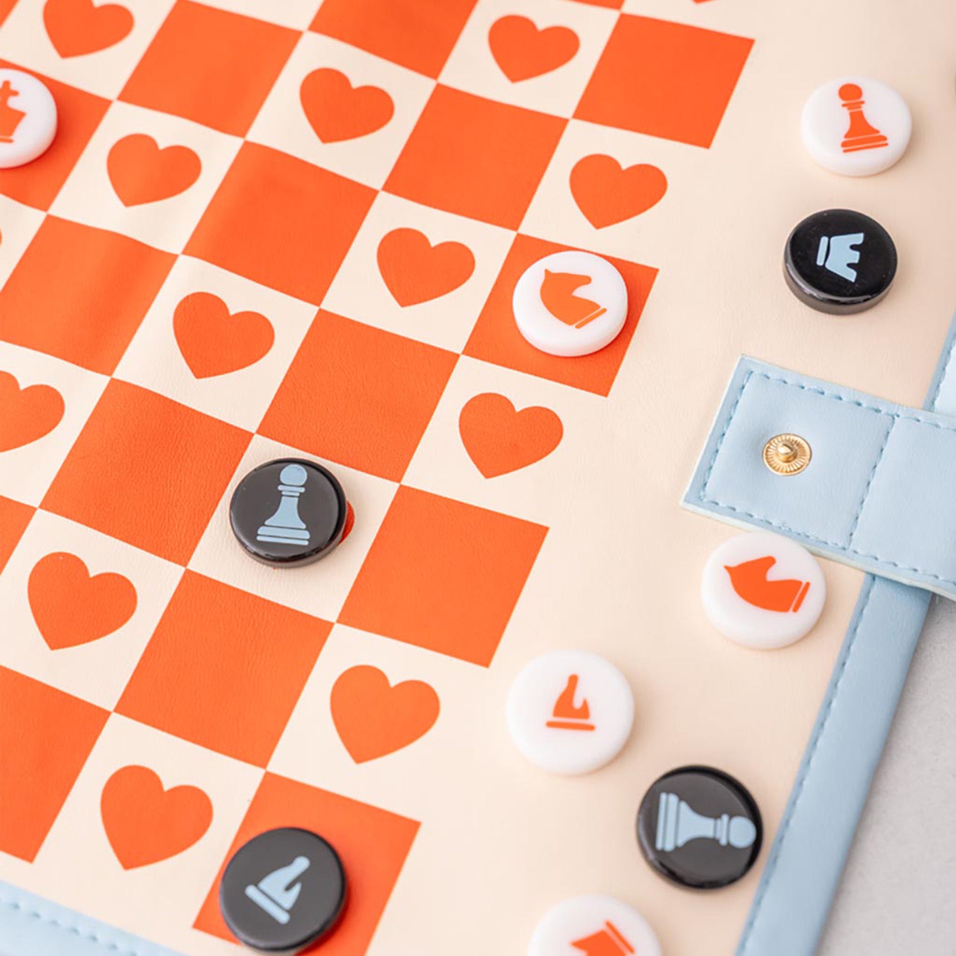 Checkered board with heart patterns and game pieces on a beige background