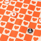 Checkered board with heart patterns and chess piece buttons on an orange and beige checkered background