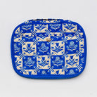 A quilted cosmetic pouch with a blue and cream floral block-print pattern, featuring a small gold metal logo on the front.