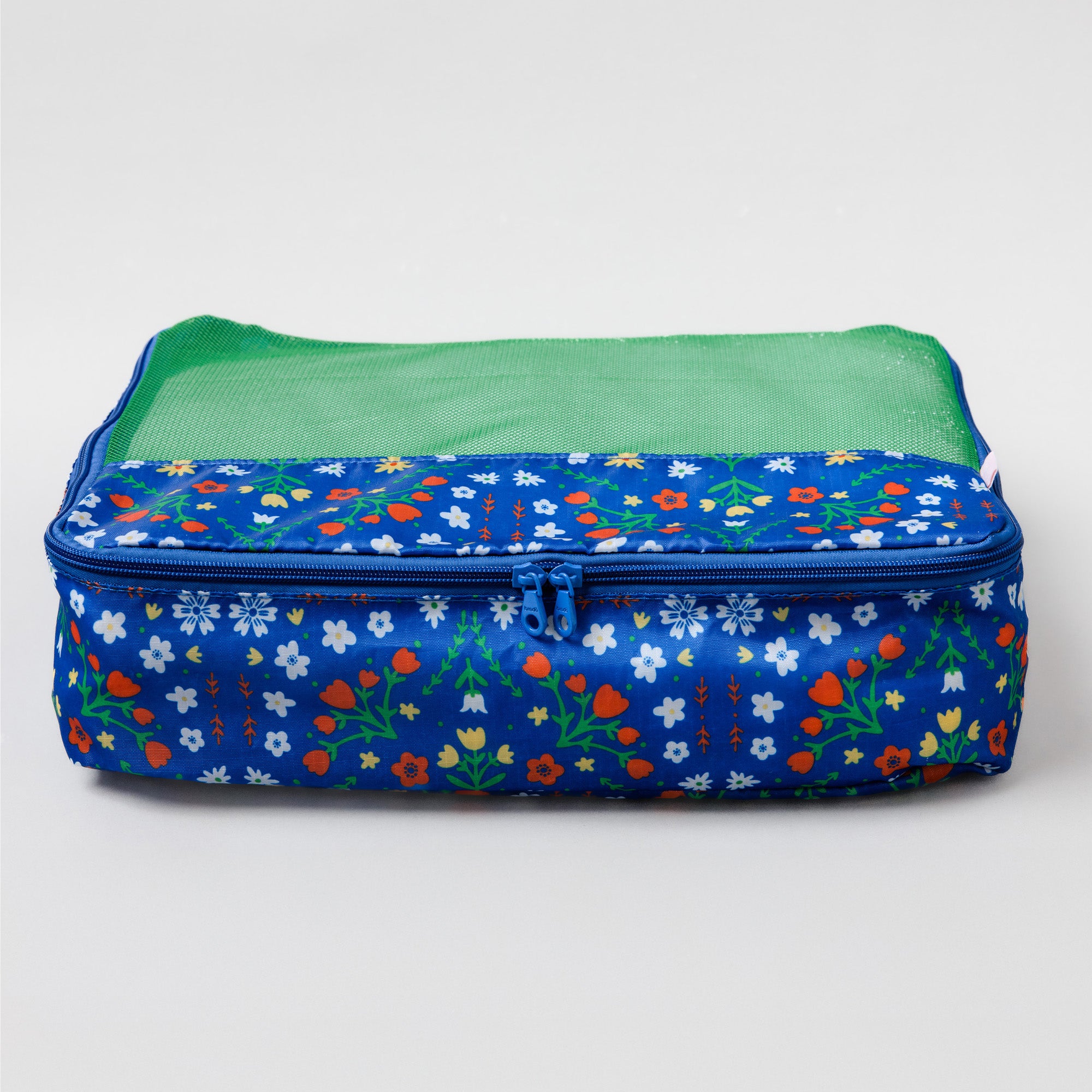 A rectangular zippered travel organizer bag with a blue floral print exterior and a green mesh interior, shown on a light gray background.
