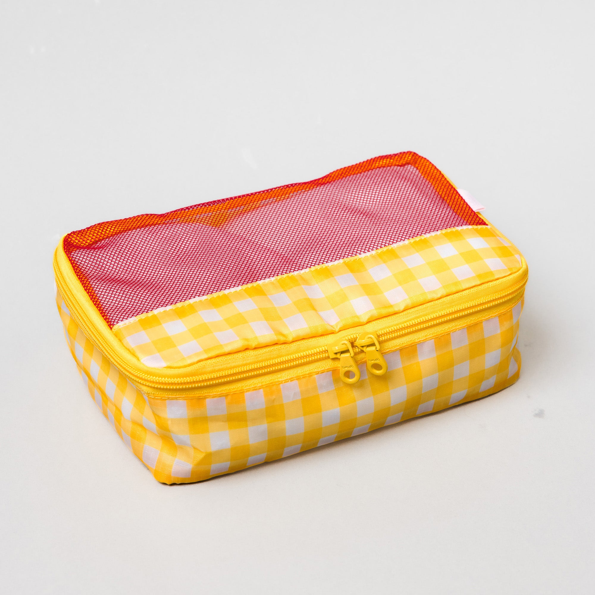 A rectangular zippered travel pouch with a yellow and white gingham pattern, featuring a pink mesh window on the lid and an orange inner lining.