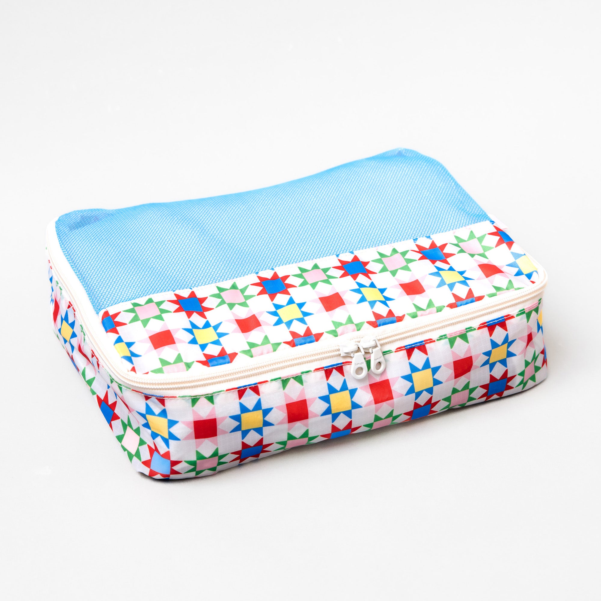 A rectangular zippered travel pouch with a light blue mesh top and a white base printed with a colorful geometric star pattern, shown on a plain white background.