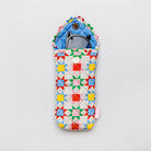 A quilted fabric pouch with a colorful geometric star pattern in red, yellow, green, blue, and pink on a white background, shown with a pair of sunglasses inside on a light gray background.