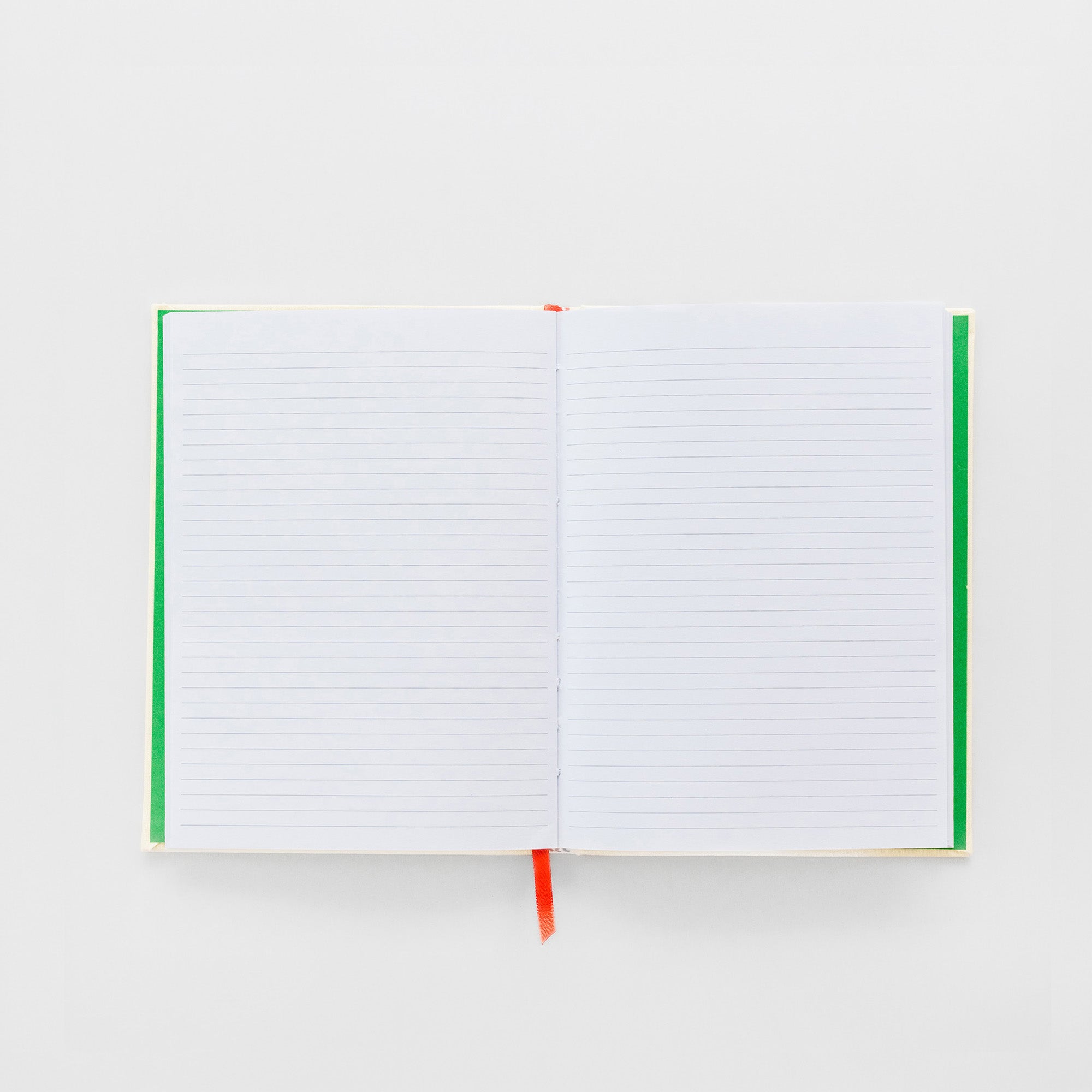 An open lined notebook with white pages, green side covers, and a small red ribbon bookmark, photographed on a clean white background.