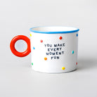A white mug with a bright red handle, blue rim, and multicolored polka dots, featuring the printed text 'YOU MAKE EVERY MOMENT FUN' on the front, set against a light gray background.