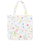 A white canvas tote bag with a colorful hand-drawn floral pattern, featuring green stems and pink, blue, yellow, and red flowers, shown against a plain white background.