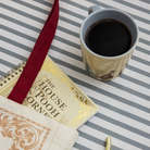 Cup of coffee next to a book titled 'The House at Pooh Corner' on a striped surface.