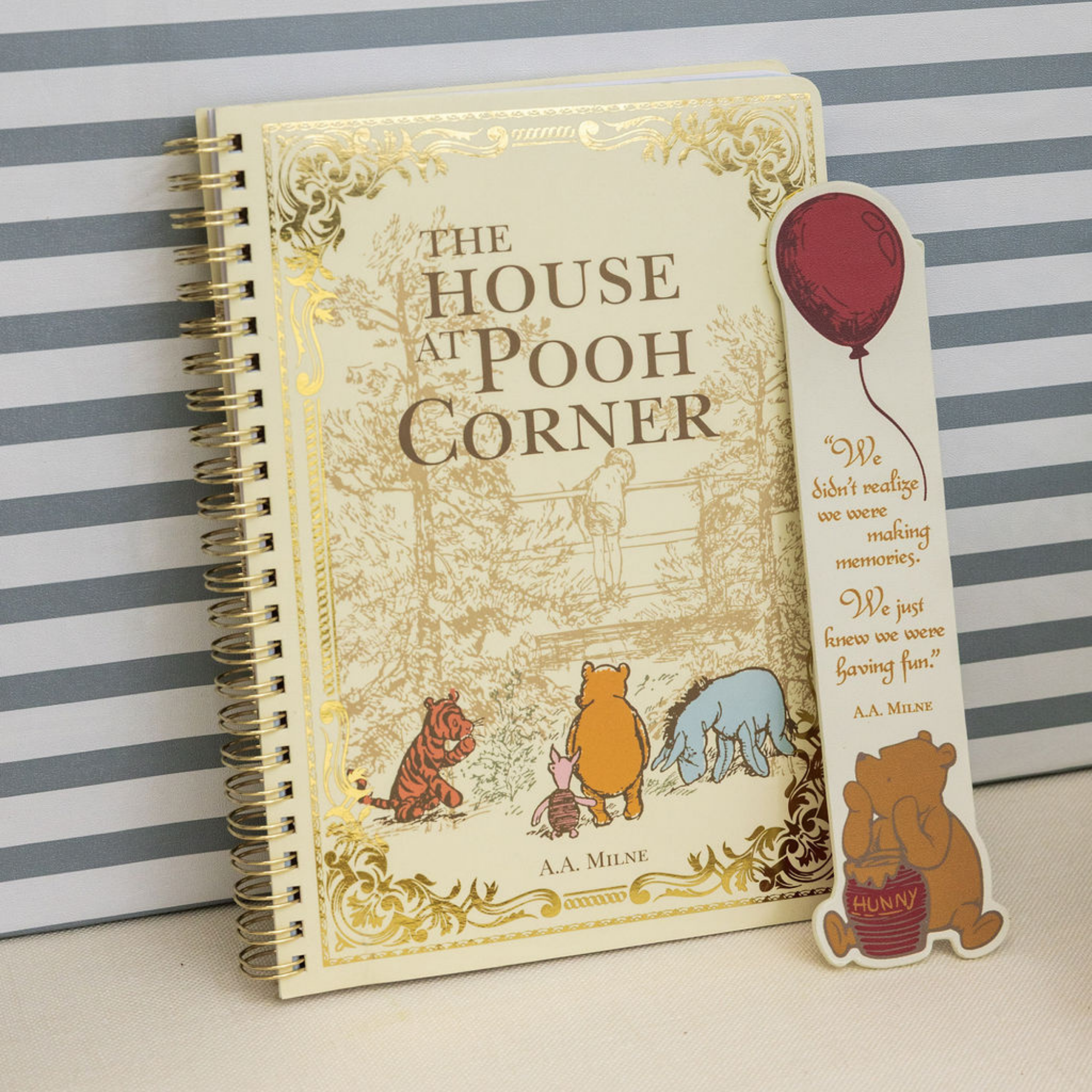 Notebook titled 'The House at Pooh Corner' with a Pooh bear sticker on a striped background