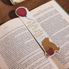Bookmark with Winnie the Pooh and a balloon on an open book