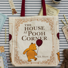 Tote bag with 'The House at Pooh Corner' design featuring Winnie the Pooh on a striped background.