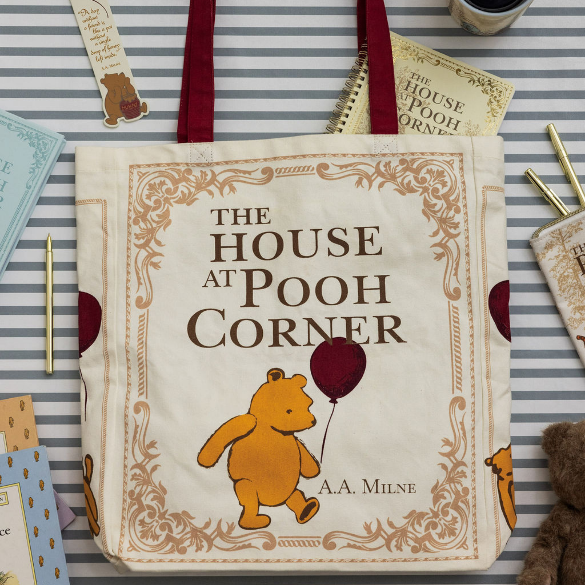 Tote bag with 'The House at Pooh Corner' design featuring Winnie the Pooh on a striped background.
