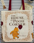 Tote bag with 'The House at Pooh Corner' design featuring Winnie the Pooh on a striped background.
