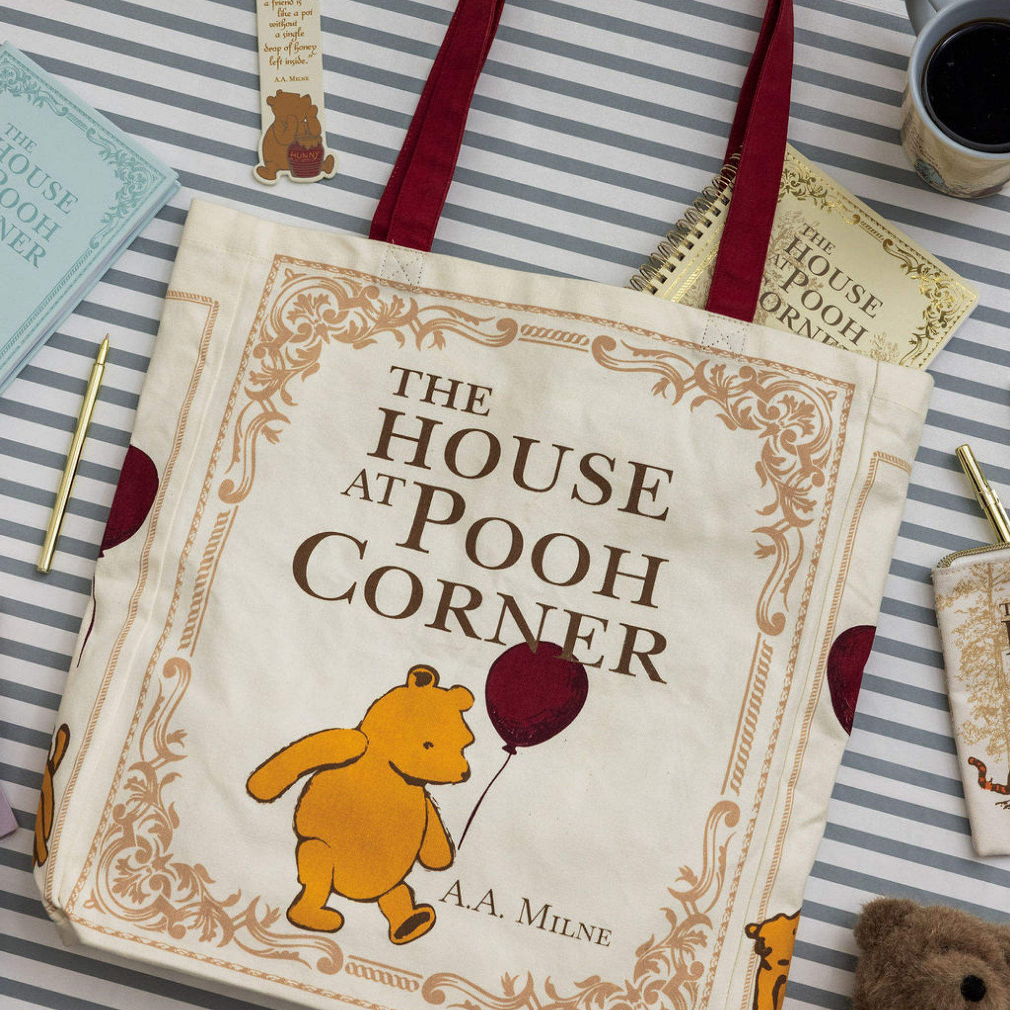 Book titled 'The House at Pooh Corner' with a bear illustration on a striped surface.