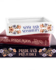 Stack of books with 'Pride and Prejudice', 'Persuasion', and 'Sense and Sensibility' on a white background