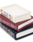 Stack of miniature books with visible titles on a white background