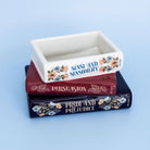 Decorative container with 'Sense and Sensibility', 'Persuasion', and 'Pride and Prejudice' on a blue background