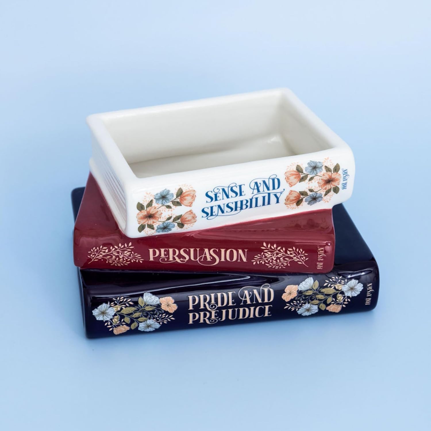 Decorative container with 'Sense and Sensibility', 'Persuasion', and 'Pride and Prejudice' on a blue background