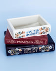 Decorative container with 'Sense and Sensibility', 'Persuasion', and 'Pride and Prejudice' on a blue background