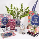Collection of 'Pride and Prejudice' themed books, mugs, and decor items on a white background with flowers.